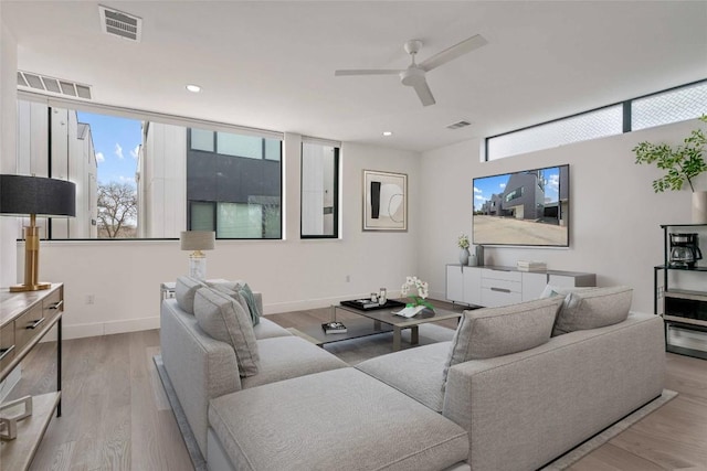 living room with ceiling fan and light wood-type flooring