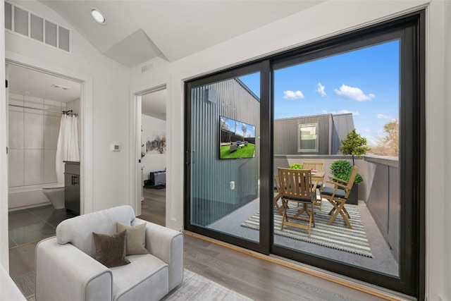 doorway to outside with hardwood / wood-style flooring and vaulted ceiling