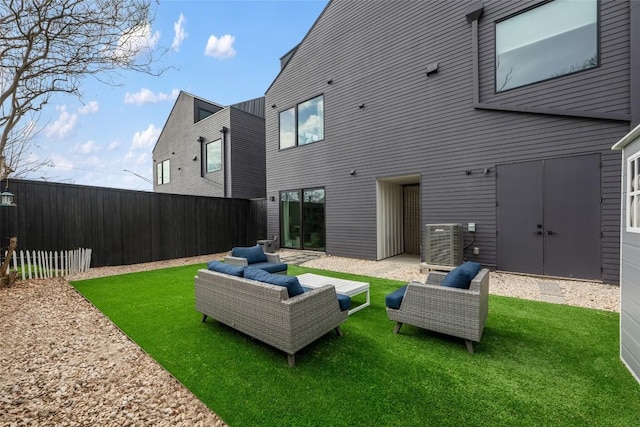 rear view of property with central AC, outdoor lounge area, and a lawn