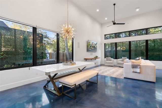 sunroom / solarium featuring ceiling fan with notable chandelier