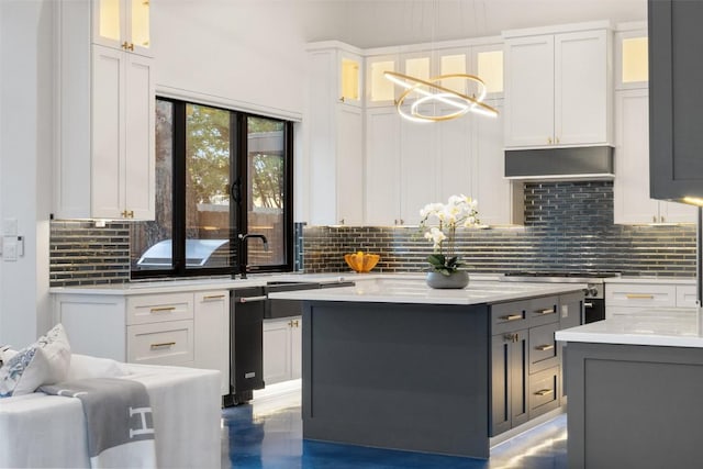 kitchen with white cabinetry, a center island, light stone counters, and hanging light fixtures