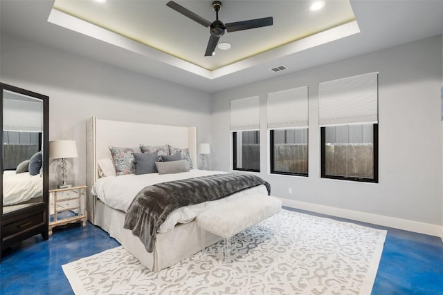 bedroom with ceiling fan and a tray ceiling