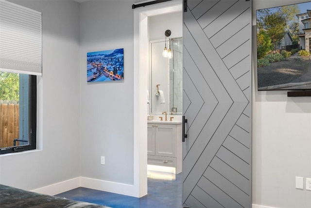 interior space featuring sink, concrete floors, and a barn door