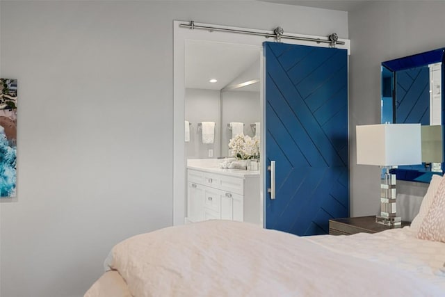 bedroom with a barn door and ensuite bath