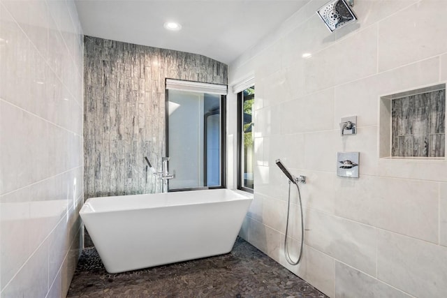 bathroom with tile walls and a bathtub