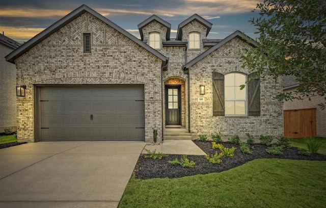 586 Biscayne Bay Bnd, Kyle, TX 78640 - french provincial home with driveway, a garage, brick siding, and a front yard