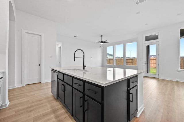 586 Biscayne Bay Bnd, Kyle, TX 78640 - kitchen with dark cabinets, ceiling fan, light wood finished floors, and dishwasher