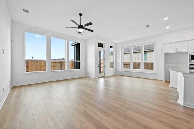 586 Biscayne Bay Bnd, Kyle, TX 78640 - unfurnished living room featuring healthy amount of natural light, ceiling fan, light wood-type flooring, and recessed lighting