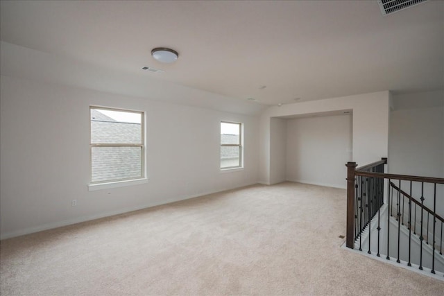 carpeted empty room featuring visible vents