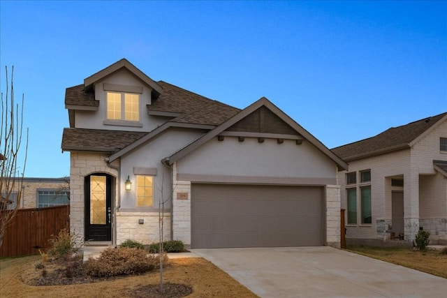 view of front facade with an attached garage, stone siding, concrete driveway, roof with shingles, and stucco siding