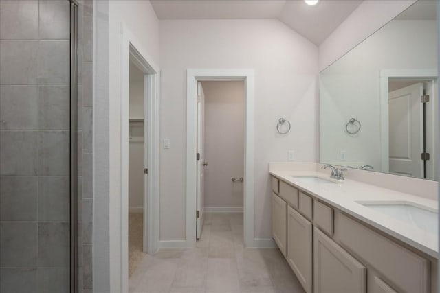 full bathroom featuring a sink, tiled shower, tile patterned flooring, double vanity, and baseboards