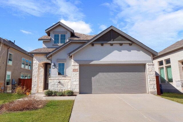 craftsman-style house featuring stone siding, stucco siding, driveway, and a garage