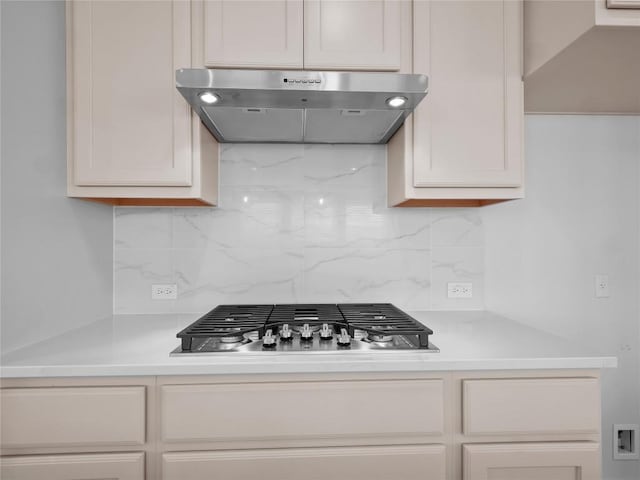 kitchen featuring backsplash, extractor fan, stainless steel gas stovetop, and light countertops