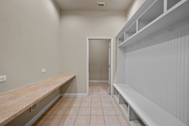 mudroom featuring built in desk and light tile patterned floors