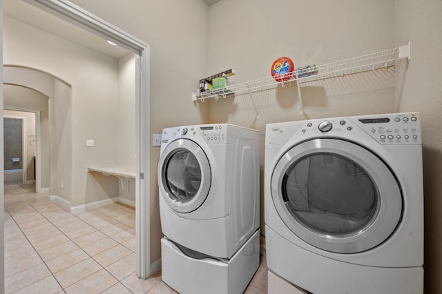 clothes washing area with light tile patterned floors and washing machine and clothes dryer