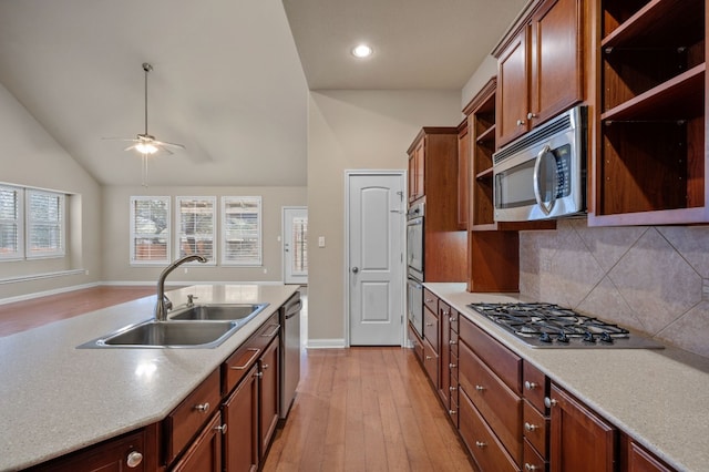 kitchen with lofted ceiling, sink, decorative backsplash, stainless steel appliances, and light hardwood / wood-style flooring