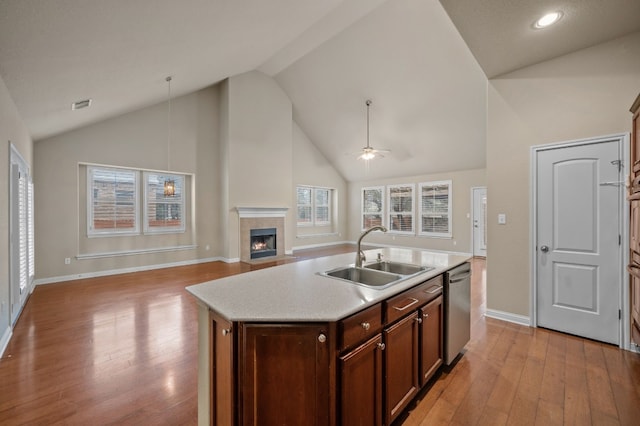 kitchen featuring sink, stainless steel dishwasher, ceiling fan, a center island with sink, and light wood-type flooring