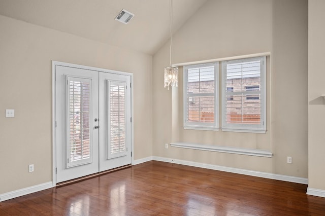 unfurnished room featuring vaulted ceiling, plenty of natural light, dark hardwood / wood-style floors, and french doors