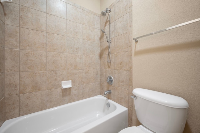 bathroom with tiled shower / bath combo and toilet