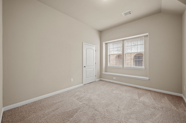 spare room with vaulted ceiling and light carpet