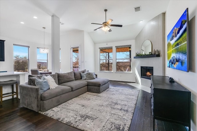 living room featuring vaulted ceiling, dark hardwood / wood-style floors, and ceiling fan with notable chandelier