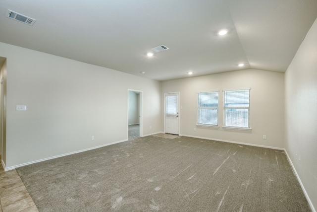 empty room featuring lofted ceiling and carpet floors