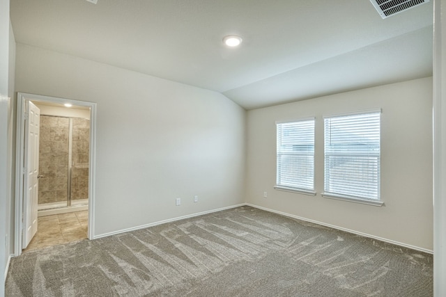 carpeted empty room featuring vaulted ceiling