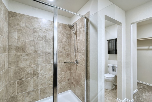 bathroom with a shower with door and toilet