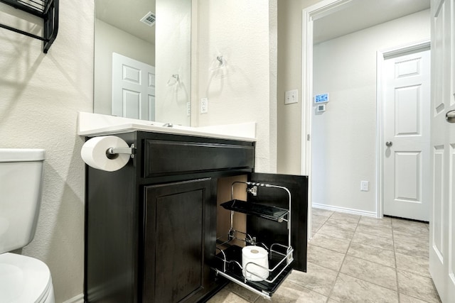 bathroom with vanity, tile patterned floors, and toilet