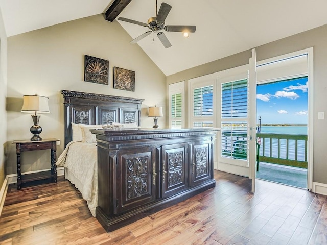 bedroom with a water view, beamed ceiling, wood-type flooring, and access to outside