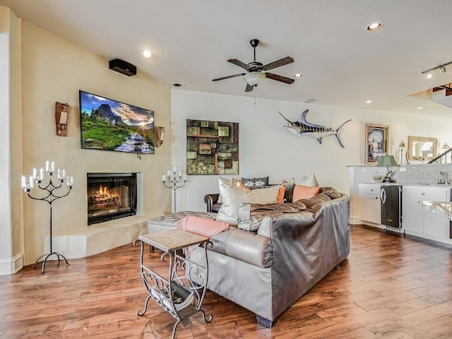 living room with ceiling fan and light wood-type flooring