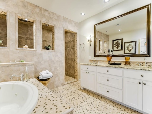 bathroom featuring vanity, tile patterned floors, tile walls, and separate shower and tub