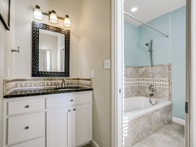 bathroom with tile patterned floors, vanity, and tiled tub