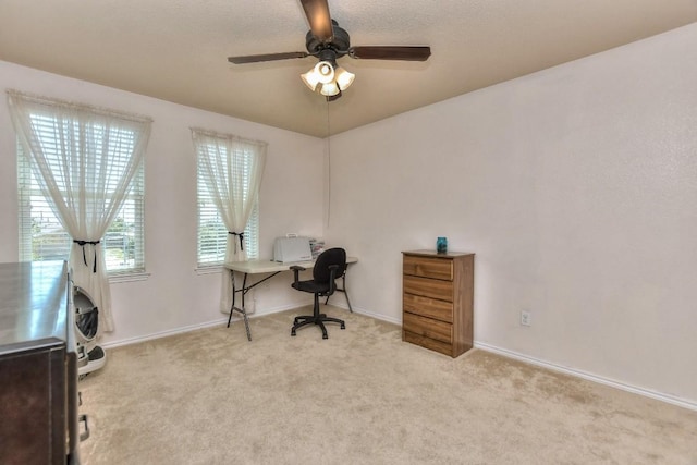 carpeted office space featuring ceiling fan