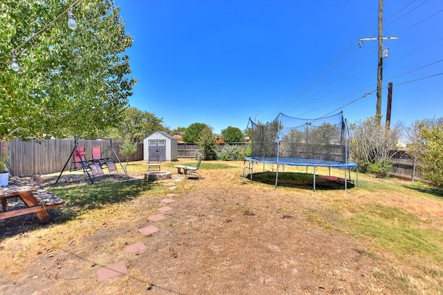 view of yard featuring a trampoline and a storage shed