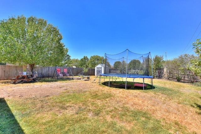 view of yard with a trampoline and a storage shed