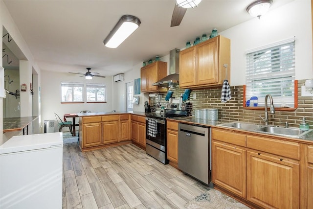 kitchen with wall chimney exhaust hood, sink, tasteful backsplash, kitchen peninsula, and stainless steel appliances