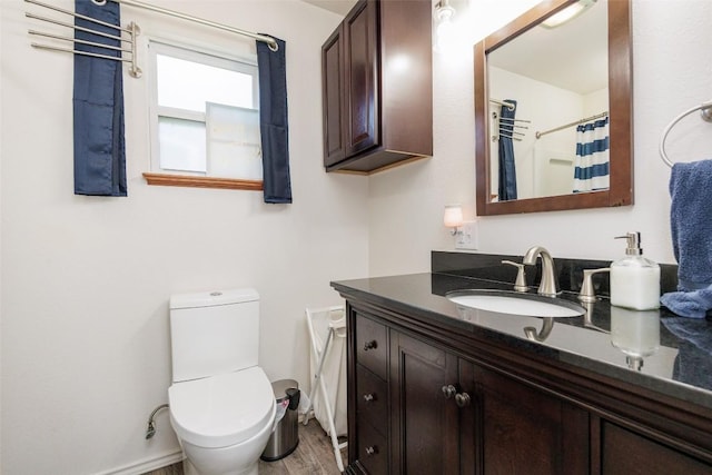 bathroom with hardwood / wood-style flooring, vanity, a shower with shower curtain, and toilet