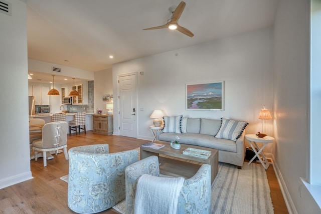 living room featuring ceiling fan and light wood-type flooring