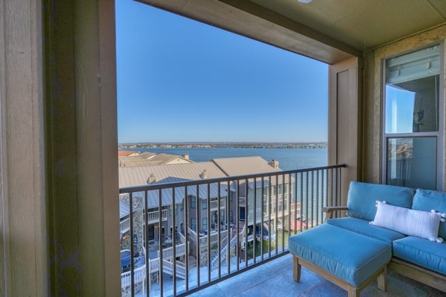 balcony with an outdoor living space and a water view