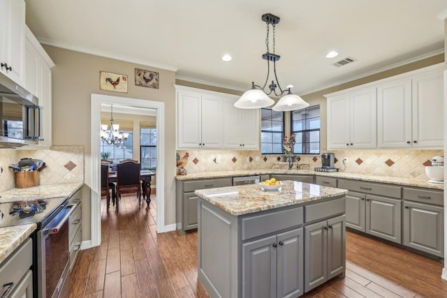 kitchen with pendant lighting, stainless steel appliances, a center island, and gray cabinetry