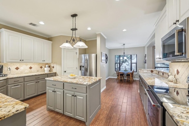 kitchen featuring gray cabinets, white cabinetry, appliances with stainless steel finishes, and pendant lighting