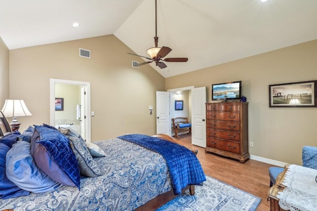 bedroom with ceiling fan, lofted ceiling, connected bathroom, and light hardwood / wood-style floors