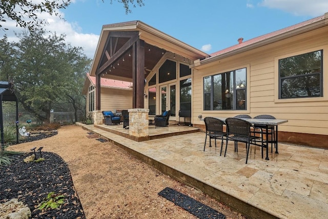 rear view of property featuring a patio, outdoor dining space, and fence