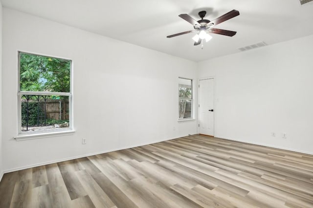 spare room with ceiling fan, plenty of natural light, and light wood-type flooring