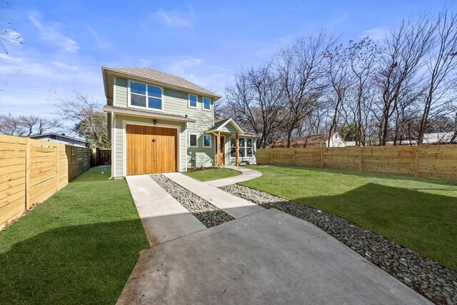 rear view of property with a fenced backyard, a garage, and a yard