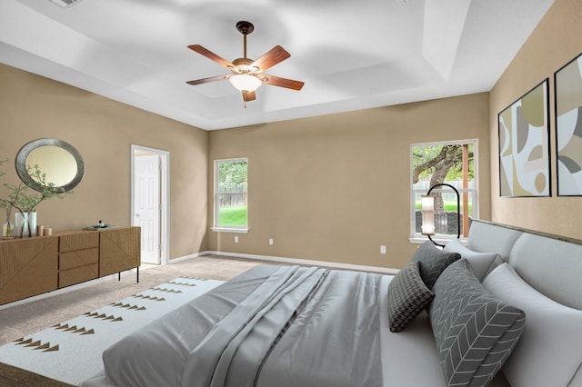 bedroom with multiple windows, light carpet, a raised ceiling, and ceiling fan