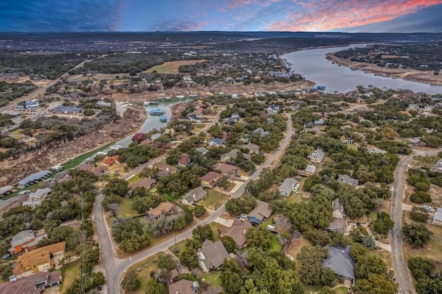 aerial view at dusk featuring a water view