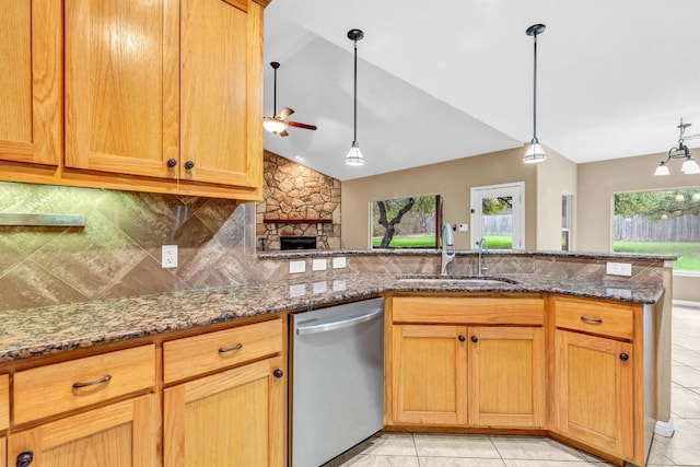 kitchen with sink, dishwasher, stone counters, decorative backsplash, and decorative light fixtures