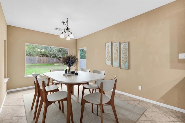 tiled dining space featuring an inviting chandelier and a wealth of natural light